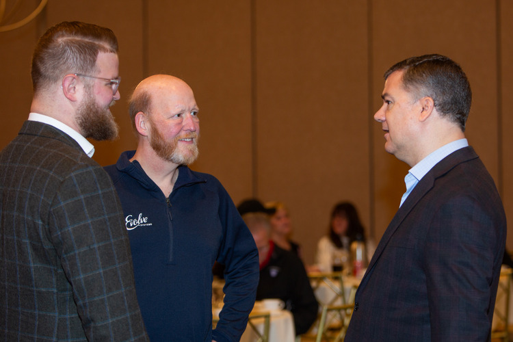 three business professionals conversing at a roundtable event
