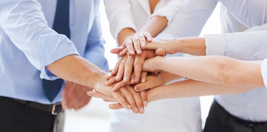 business professionals stacking their hands to celebrate