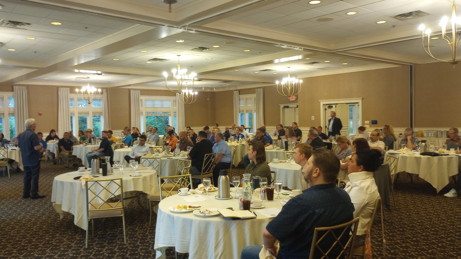 group of 30+ people sitting at tables attending an event